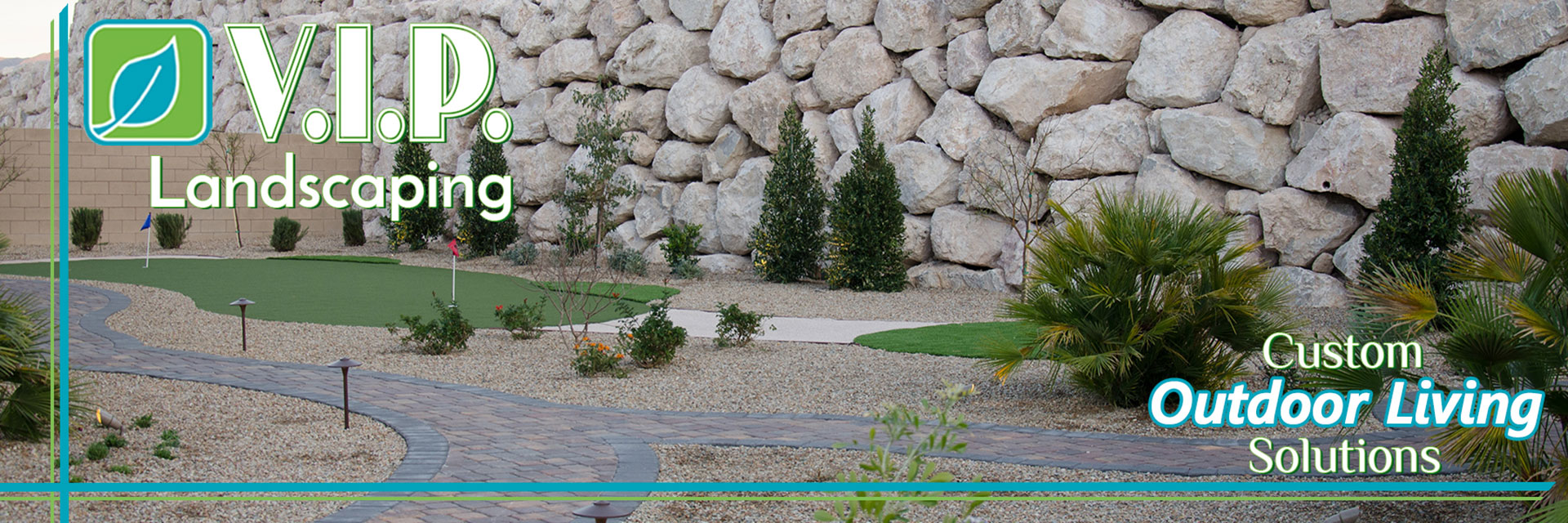 Putting green with boulder rock wall and pavers pathways combined with desert landscaping